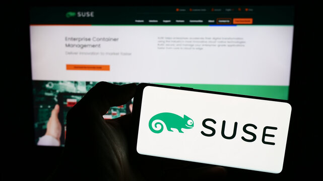 Stuttgart, Germany - 09-10-2023: Person holding cellphone with logo of open-source software company SUSE S.A. on screen in front of business webpage. Focus on phone display.