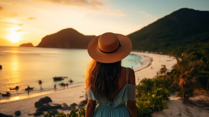 Beautiful young woman with long brown hair and wearing a hat watching the golden sunset at beautiful beach.