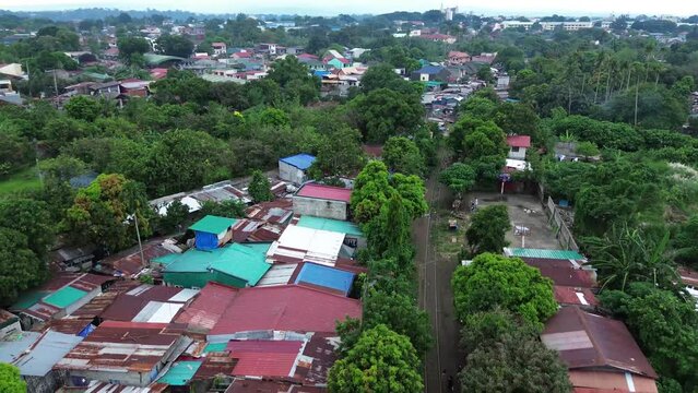 Corroded roofs of illegal row of housing settlements along rail road tracks. Drone aerial shot.