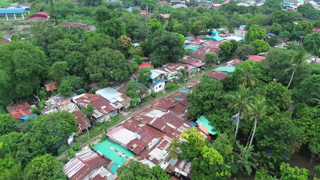 Corroded roofs of illegal row of housing settlements along rail road tracks. Drone aerial shot.