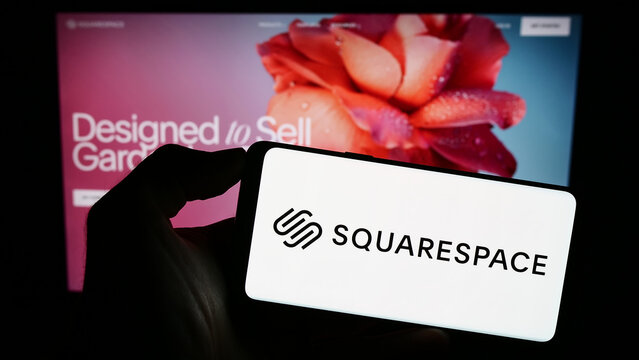 Stuttgart, Germany - 09-11-2023: Person holding smartphone with logo of US website building company Squarespace Inc. on screen in front of webpage. Focus on phone display.
