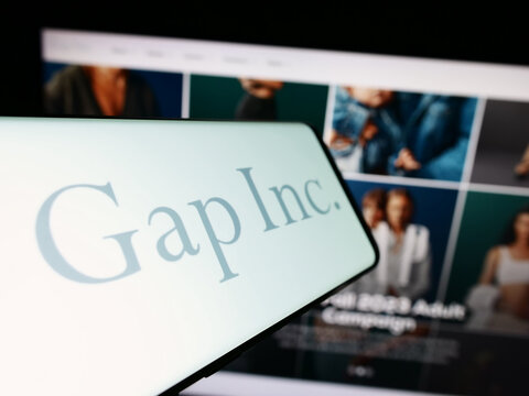 Stuttgart, Germany - 09-13-2023: Mobile phone with logo of US clothing and accessories company Gap Inc. on screen in front of website. Focus on center-left of phone display.