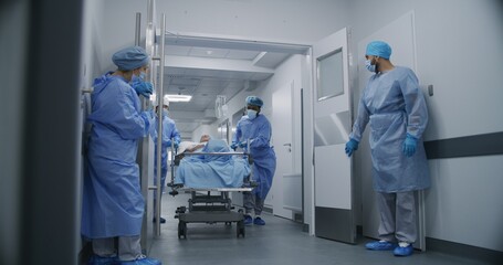 Nurse and paramedic quickly open medical facility corridor doors. Multi ethnic surgeons push...
