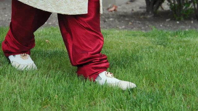 Close up view of Indian Groom wearing traditional wedding Wear Sherwani,  groom walk on grass