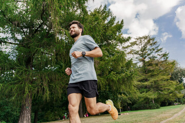 Motivation and mental health playing sports. Interval endurance training. A professional running instructor in sneakers doing a workout alone. Young man fitness exercises.