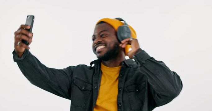 Fashion, black man or influencer taking a selfie in studio on social media with peace sign or smile. Headphones, cool or happy African guy taking a photo, vlog or picture isolated on white background