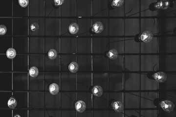A group of a lot of white light bulbs ceiling interior element dark background abstract