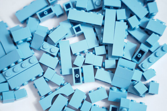 A collection of light blue building blocks legos on white background. 