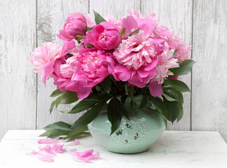 Bouquet of pink peonies in ceramic turquoise vase