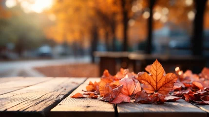  autumn yellow leaves on a wooden table against the background of a blurred image of an autumn landscape on a sunny day © Margo_Alexa