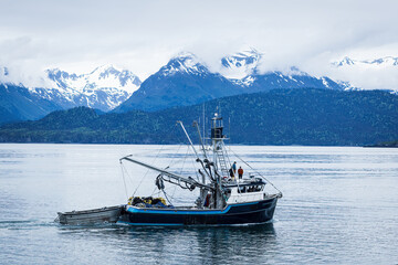 Fishing boat leaving the harbor, Homer, Alaska. The Kenai Mountains in the background.