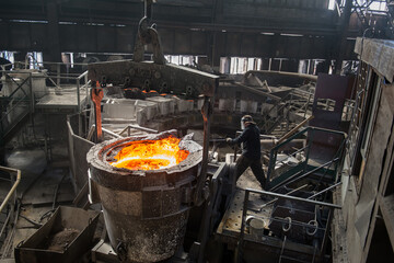 Steelworker at work near the tanks with hot metal - 648182777