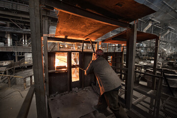 Steelworker at work near the tanks with hot metal - 648182913