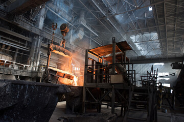 Steelworker at work near the tanks with hot metal - 648182949
