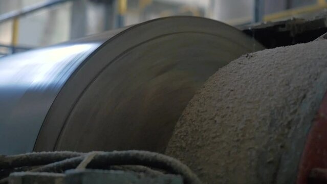 Shot of shaft at a cardboard factory. Spinning shaft is formating a cardboard sheet. Extreme close-up
