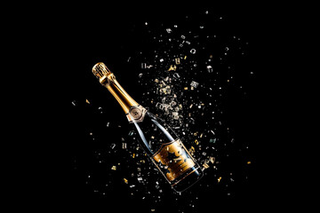bottle of champagne with confetti on black background. Celebration and new year concept