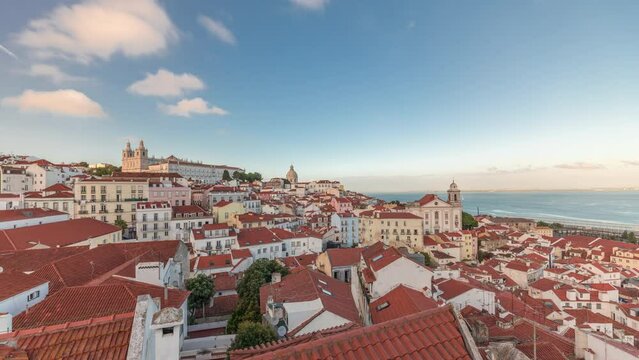 Panorama showing aerial view of Alfama in Lisbon timelapse during sunset. Red roofs in the oldest district of the Old Town, with National Pantheon from belvedere Miradouro das Portas do Sol, Portugal.