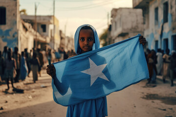 Une fille somalienne tenant le drapeau de la Somalie, dans une rue de Mogadiscio - obrazy, fototapety, plakaty