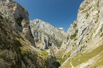 The mountains and hiking trails of the picos de europa in Spain. These bright landscape images during the summer of the Spanish mountainsides showcase the rocky and dry environment. Lush green trails.