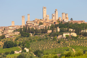 Fototapeta na wymiar San Gimignano village, Italy: green countryside, blue sky, hill panorama with town and towers