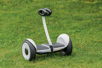Fototapeta premium Hoverboard object is a street modern electric vehicle against the background of grass in the park