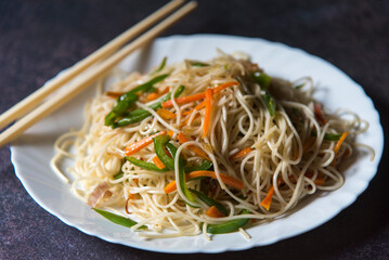 Chinese dish vegetable noodles served in a plate. Close up, selective focus.