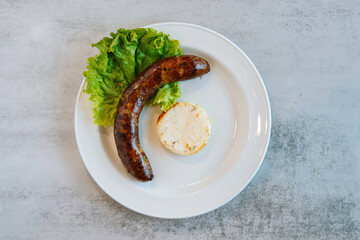 grilled sausage on a plate with an arepa columbian food