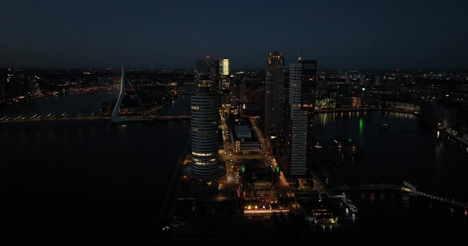 Aerial drone view of the Kop van Zuid, city high rise skyline at night. Rotterdam, The Netherlands.