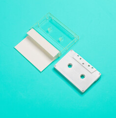 Retro 80s audio cassette and box with blank label on blue background. Music concept, mockup for...