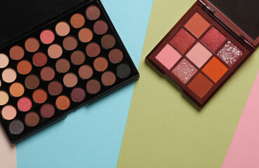 Makeup palettes on a colored background. Top view