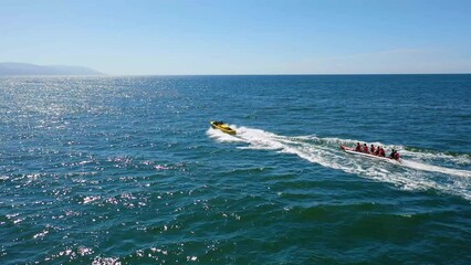 Vacation goers having fun on a banana boat ride across the ocean.