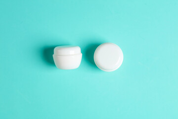 White cream jars on a blue background. Mockup, template for design. Top view