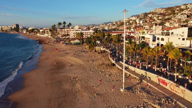 Aerial drone footage of the Flyers of Papantla in Puerto Vallarta, a cultural performance on the beach during golden hour sunset.