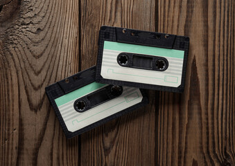 Retro 80s audio cassettes on wooden background. Music concept, vintage technology. Top view.