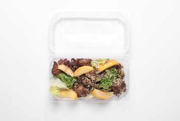 Salads in a plastic box on a white background. Tekaway food. Top view