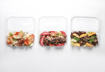 Different Salads in a plastic box on a white background. Tekaway food.