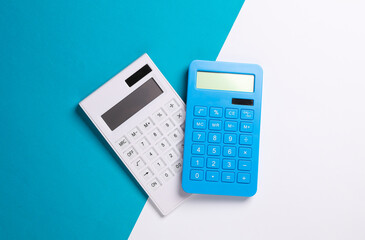 Two calculators on a blue white background. Top view