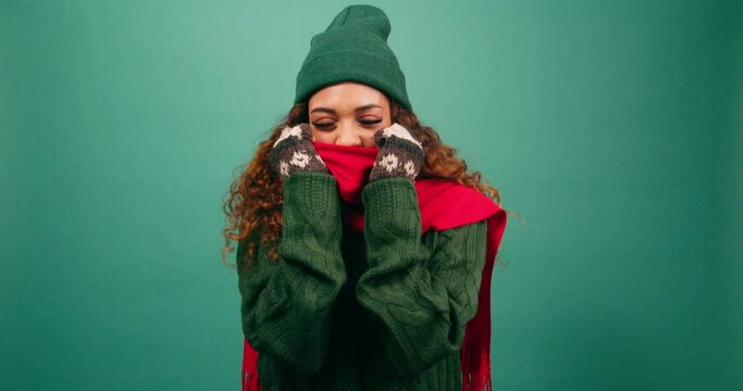 Freezing cold woman bundles up against the cold, huddles in warm scarf, studio