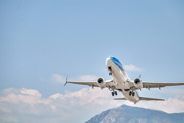 blue and white plane just after takeoff