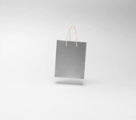 Miniature shopping bag levitating on gray background