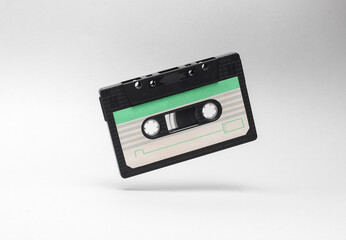 Retro audio cassette levitating on white background. Minimalism