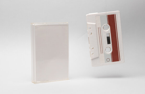Retro audio cassette with box levitating on white background