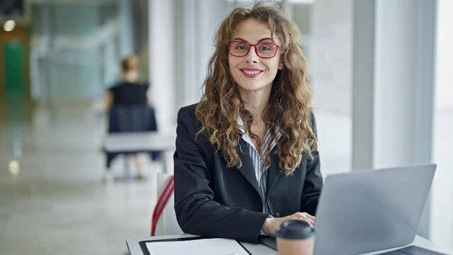 Young woman business worker using laptop smiling at the office