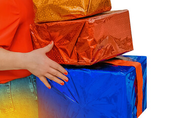 The hands of an adult girl hold a lot of gift colored New Year's boxes in packaging film against the background Christmas isolated, white, close up