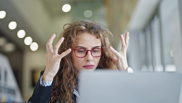 Young woman business worker using laptop angry at the office