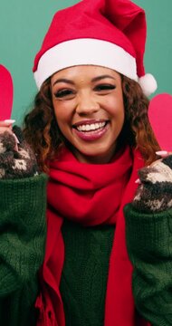 Beautiful young woman covers eyes with heart shapes, love at Christmas time