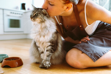 Caring for pet. teenage girl feeding domestic cat