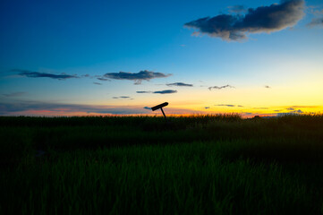 Fototapeta na wymiar silhouette cross sign on graveyard grass land in evening sunset sky