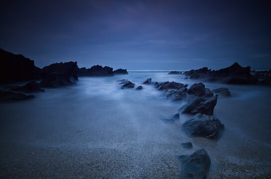 Long exposure of rocks on the beach at night; Newquay cornwall england