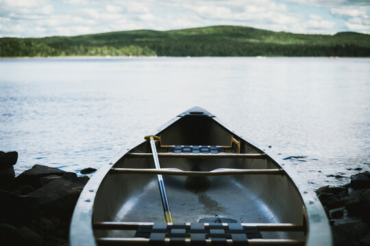 Fiberglass canoe at lakeside with mountain on the horizon; Thetford mines quebec canada